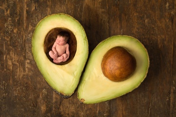 Baby sleeping in open avocado