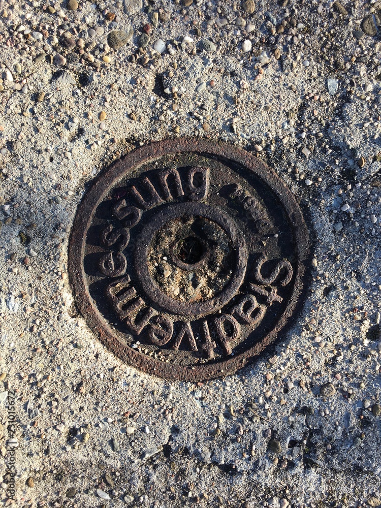 Metallsymbol der Stadtvermessung im Boden eines Weinbergwegs in Esslingen (Baden-Württemberg)
