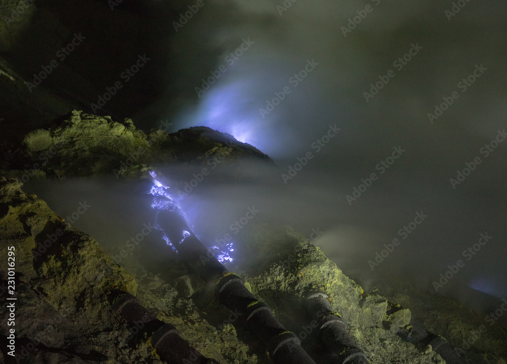 Blue Flame from the Mount Ijen sulfur mines inside the crater next to ...