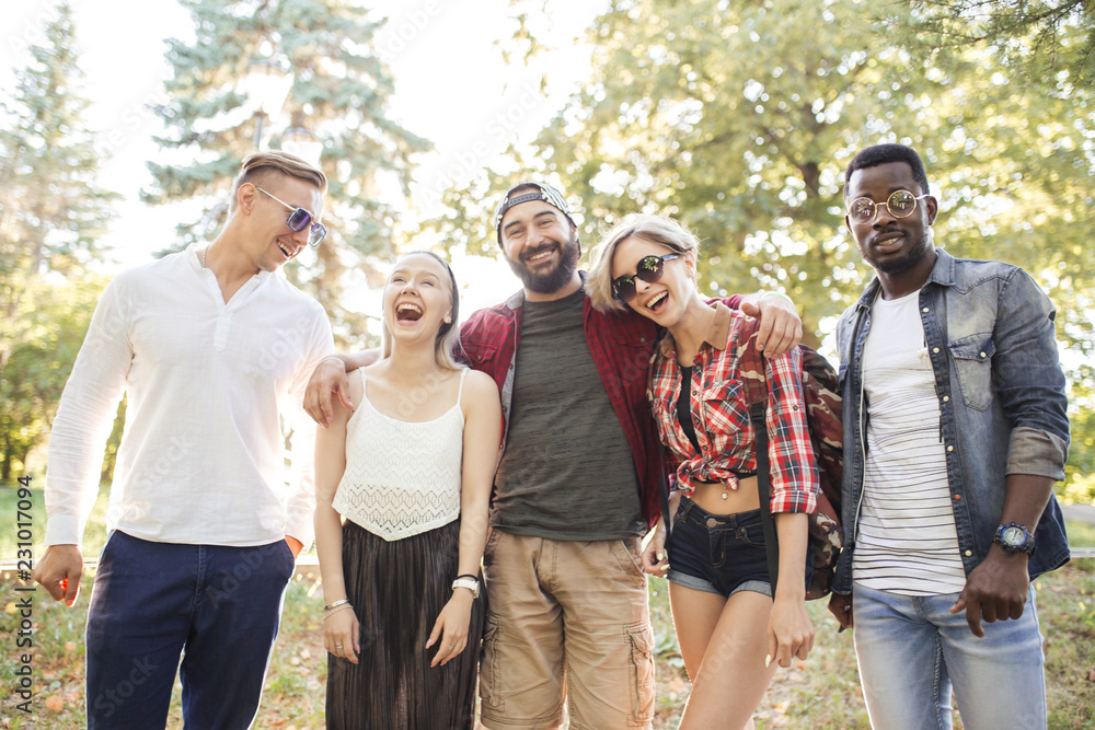 Group of multiracial friends dressed in casual summer clothing with  smartphone having fun together at park, watching funny video in social  media. Stock Photo | Adobe Stock
