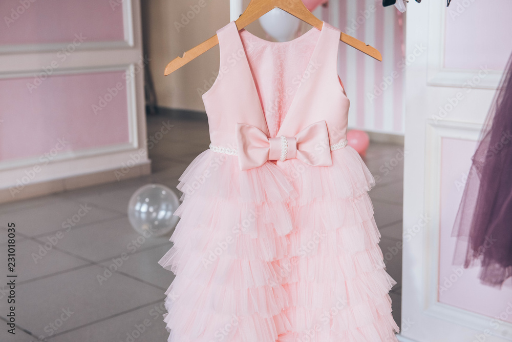 Clothing for a little girl on a clothes rack in a wardrobe. Fashion ...