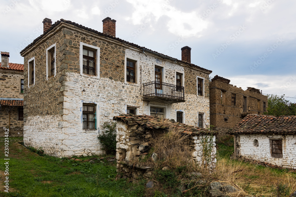 Old buildings, made of stone and mud bricks, at the abandoned village of Mileones in the area of Prespes Lakes in Greece