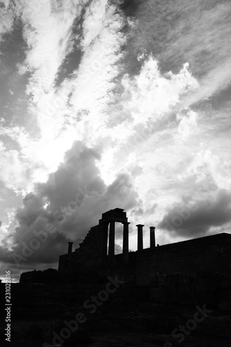 Tempelruine auf Akropolis mit Saulen und Tympanon unter einem dramatischen Wolkenhimmel