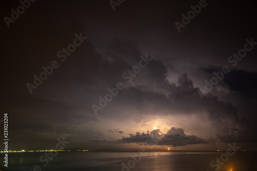 Thunderstorm over the sea, lightning beats the water