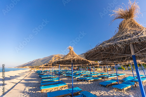 Sunrise over an empty beach with umbrellas