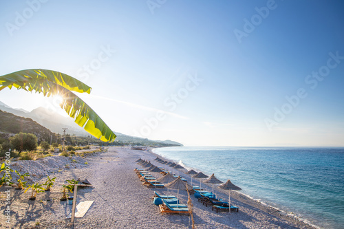 Sunrise over an empty beach with umbrellas photo