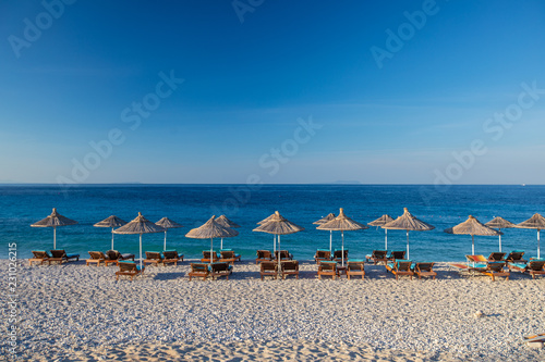 Sunrise over an empty beach with umbrellas