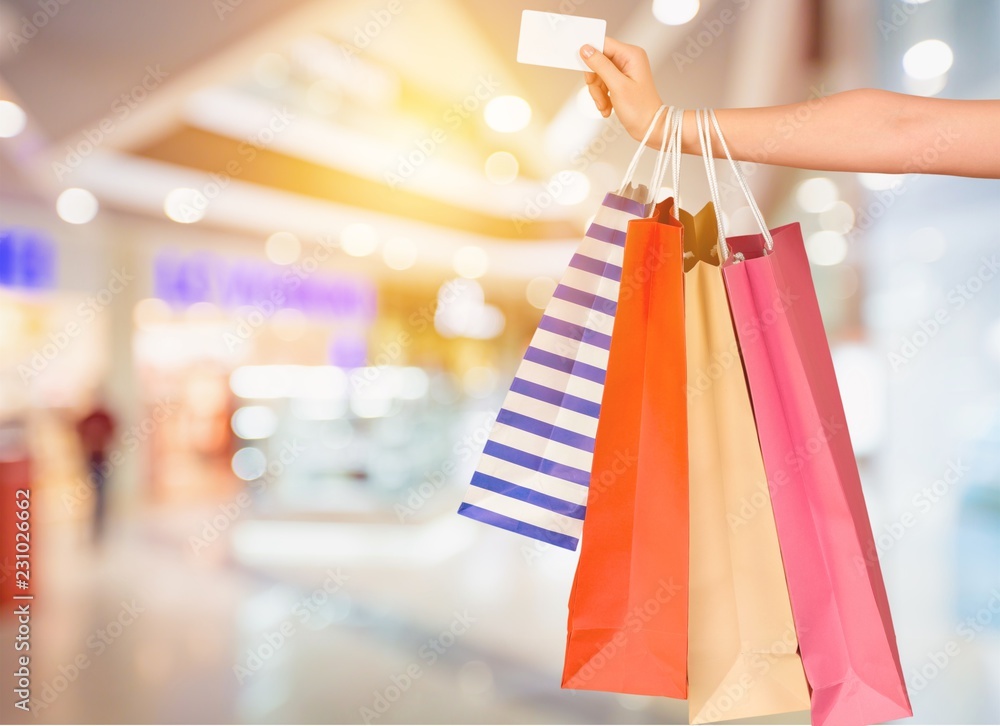 Woman with shopping bags and card on mall background Woman with shopping bags and card on mall background