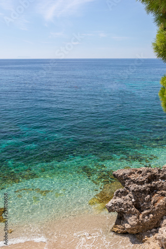 Fototapeta Naklejka Na Ścianę i Meble -  White beach with rocks in the turquoise clear sea
