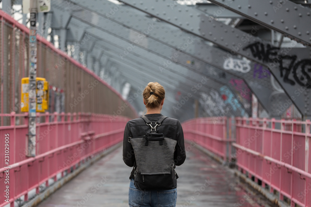 Φωτογραφία Solo casual woman walking the cycling lane on Williamsburg Bridge, Brooklyn, New York City, USA on overcast day