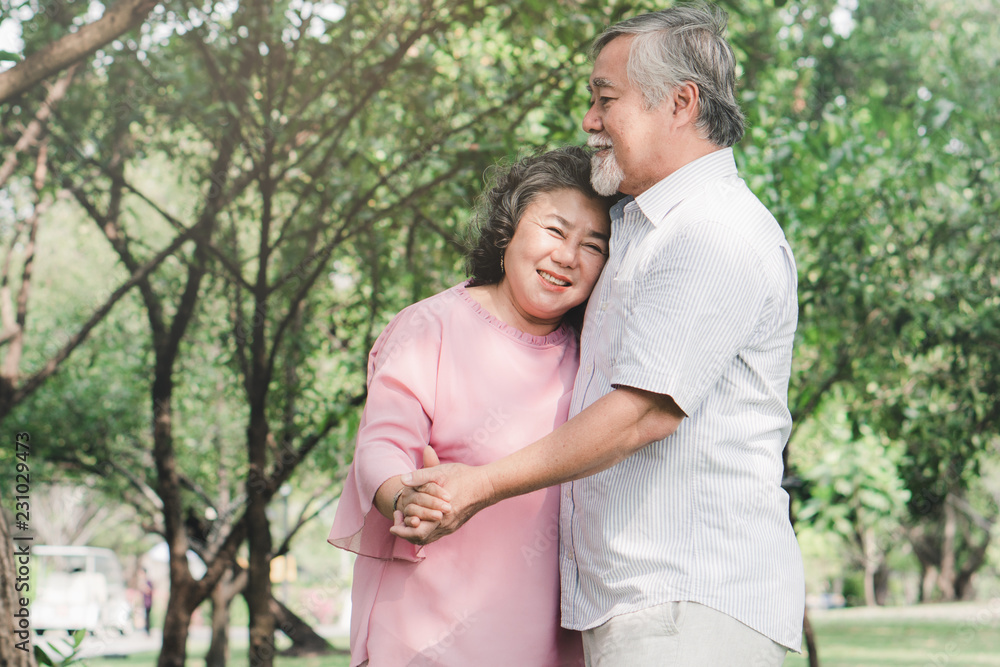 Fototapeta premium Happy elderly couple with lifestyle after retiree concept. Lovely asian seniors couple embracing together in the park in the morning.