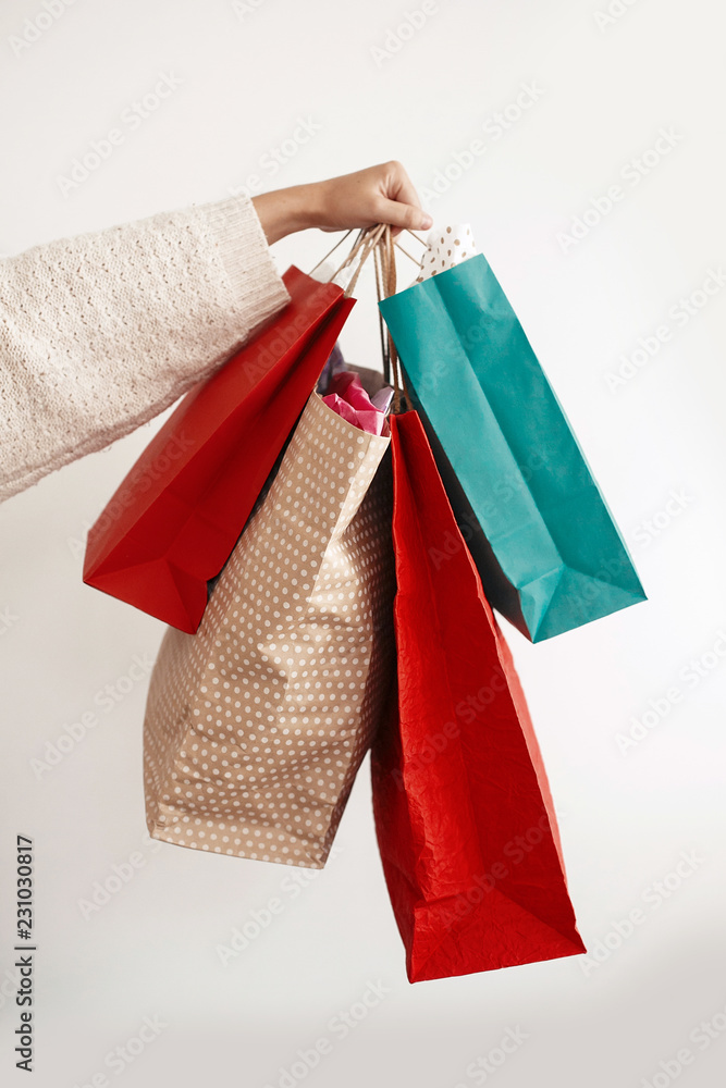 Christmas Shopping and seasonal sale. Happy Girl holding colorful shopping bags on white background isolated. Christmas Sales. Space for text.  Black Friday. Cyber Monday