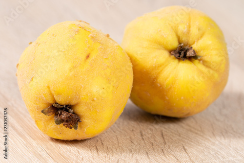 Close up of yellow quinces on wooden background in the kitchen 