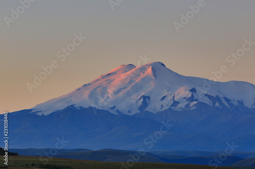 Mount Elbrus at dawn. View of the sunlit slopes of the volcano from the northwest. The North Caucasus in Russia.