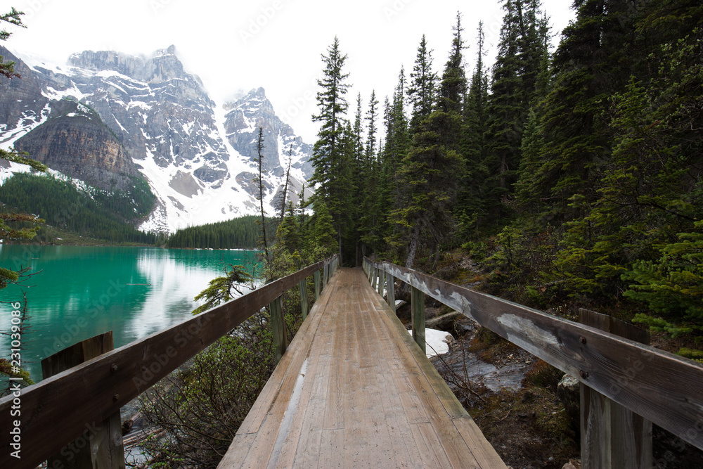 Wooden bridge at the Moraine lake on a rainy day