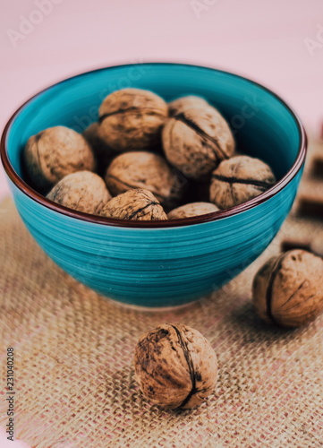 a bowl with walnuts on wooden background