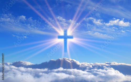 religious cross over cumulus clouds illuminated by the rays of holy radiance, concept