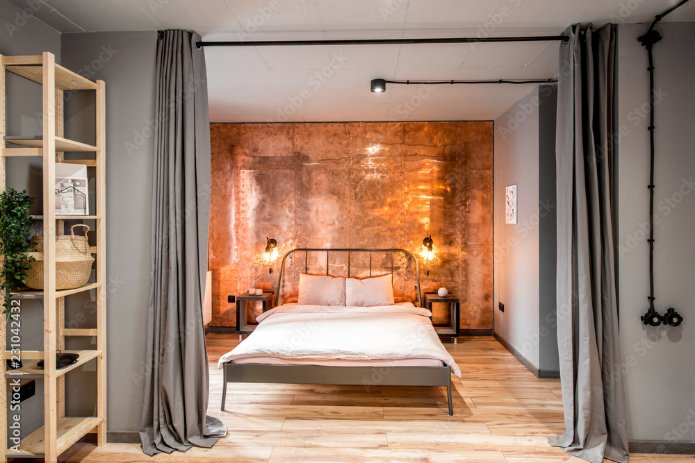 Modern loft bedroom interior with wall made of copper metal. Real photography Modern loft bedroom interior with wall made of copper metal. Real photography