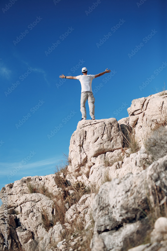 Fototapeta premium Young male rock climber on a cliff top