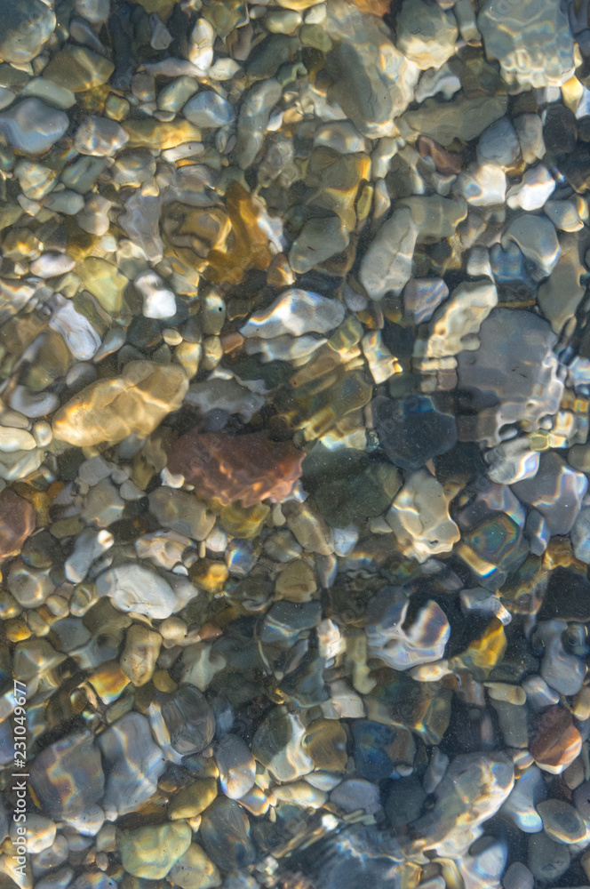 sea pebble beach with multicoloured stones, waves with foam sea pebble beach with multicoloured stones, waves with foam