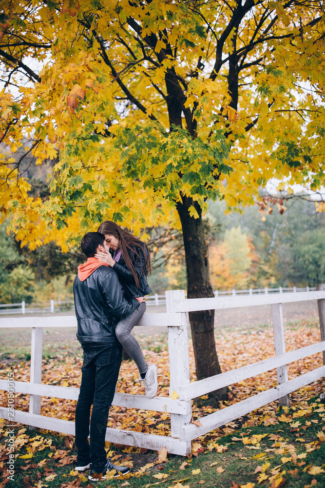 Fototapeta premium Romantic holidays guy and girls in autumn park. Funny games of husband and wife in nature.