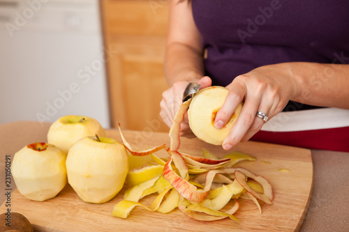 Young Woman Peeling Apples in Kitchen at Home