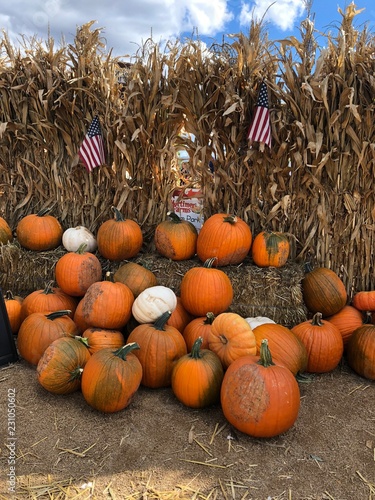 Layers of Pumpkins with hay bales and American flags