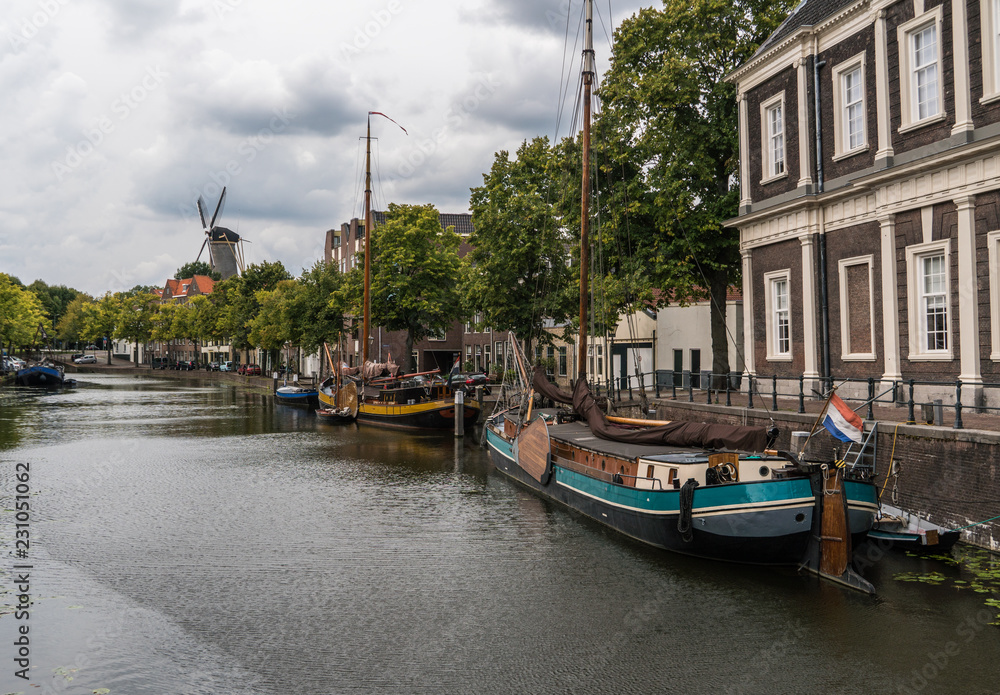 Traditional wooden sailing ships in water channel. Old historic harbor of Schiedam, The Netherlands