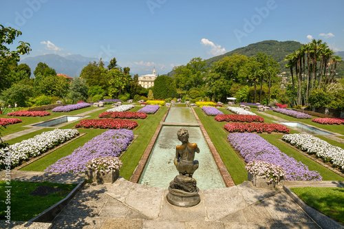 Panorama di un giardino classico italiano con bordure di fiori colorati, vasche d'acqua e statua, Villa Taranto, Lago Maggiore, Piemonte, Italia