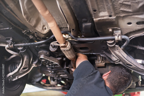 Mechanic repairing exhaust system