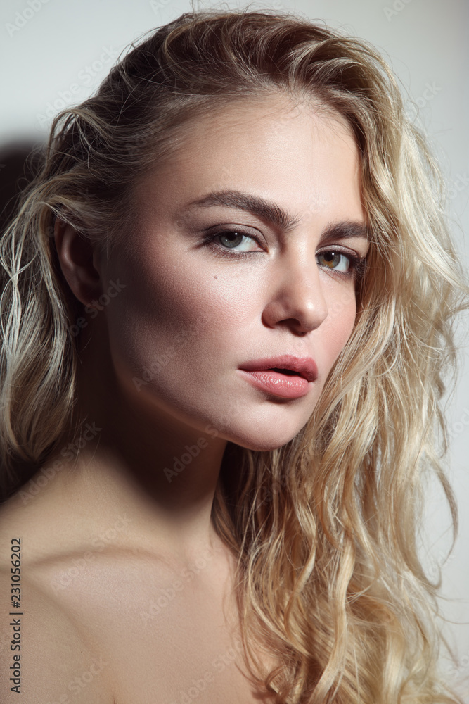 Fototapeta Portrait of young beautiful woman with blond curly messy hair