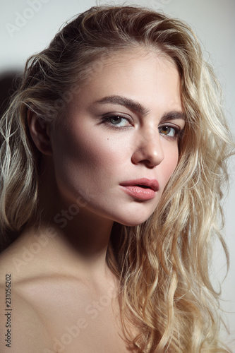 Portrait of young beautiful woman with blond curly messy hair