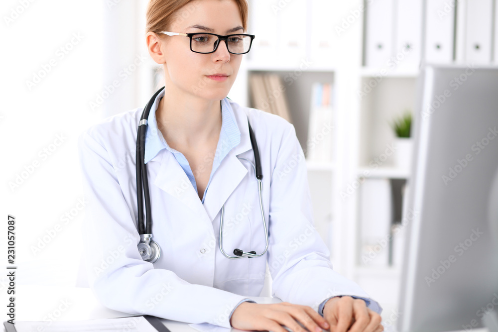 Young brunette female doctor at work in hospital. Physician ready to help. Medicine and healthcare concept Young brunette female doctor at work in hospital. Physician ready to help. Medicine and healthcare concept
