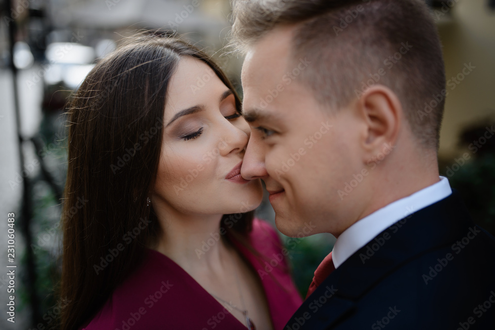 Young couple in a candid shot. They are walking in the street.