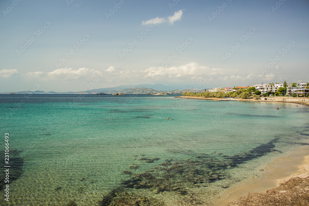 Mediterranean sea shore bay beautiful landscape with vivid water green and blue surface and rock horizon background in summer warm sultry weather