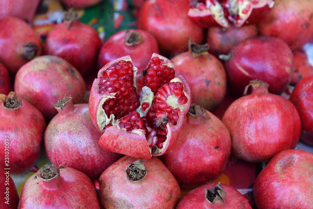 A heap of pomegranates with an opened one in the middle on a market in Mexico. A heap of pomegranates with an opened one in the middle on a market in Mexico.