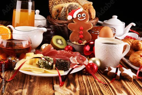 breakfast on table with bread buns, croissants, coffe and juice on christmas day. xmas holiday morning.
