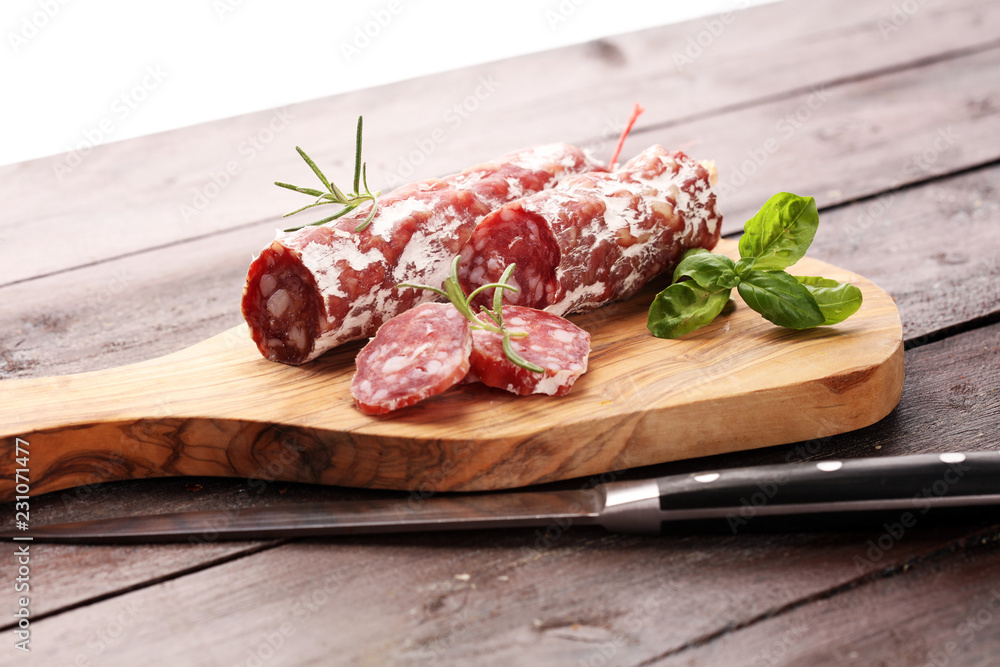 thinly sliced salami on a wooden texture on the background. thinly sliced salami on a wooden texture on the background.