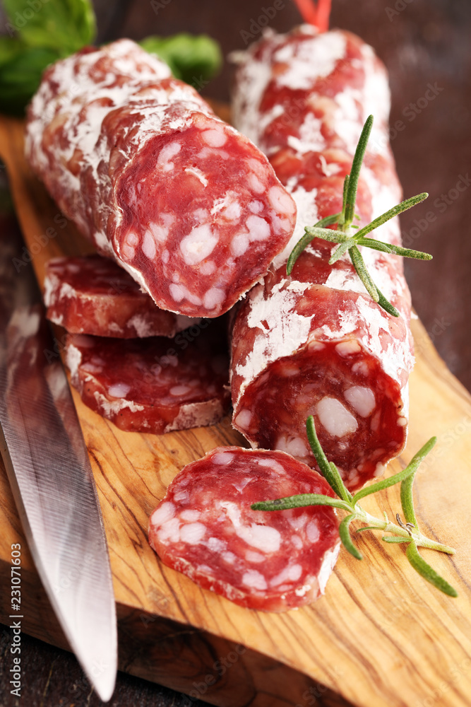 thinly sliced salami on a wooden texture on the background. thinly sliced salami on a wooden texture on the background.