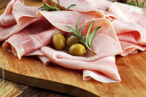 Sliced ham on wooden background. Fresh prosciutto. Pork ham sliced.
