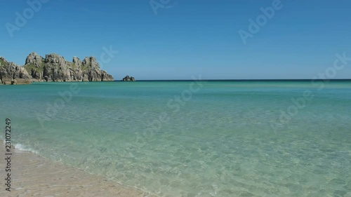 Views across Pedn Vounder Beach towards Logan's Rock, Cornwall, England on a clear sunny June day.