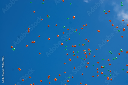 Flying colorful balloons in the city festival on blue sky background. 