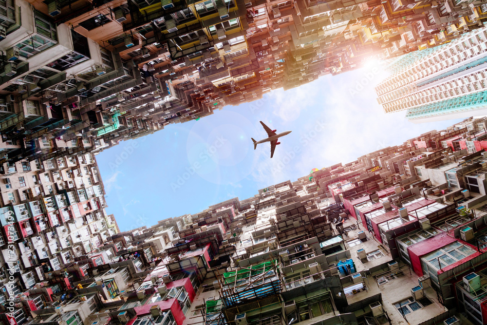 Obraz premium Samolot lecący nad zatłoczonymi domami w Quarry Bay w Hongkongu