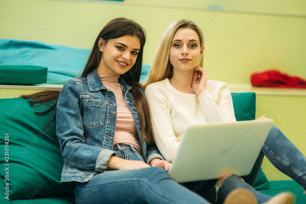 Happy student have a break in university. Have a good time while using phone , tablet and laptop. Two girls Happy student have a break in university. Have a good time while using phone , tablet and laptop. Two girls