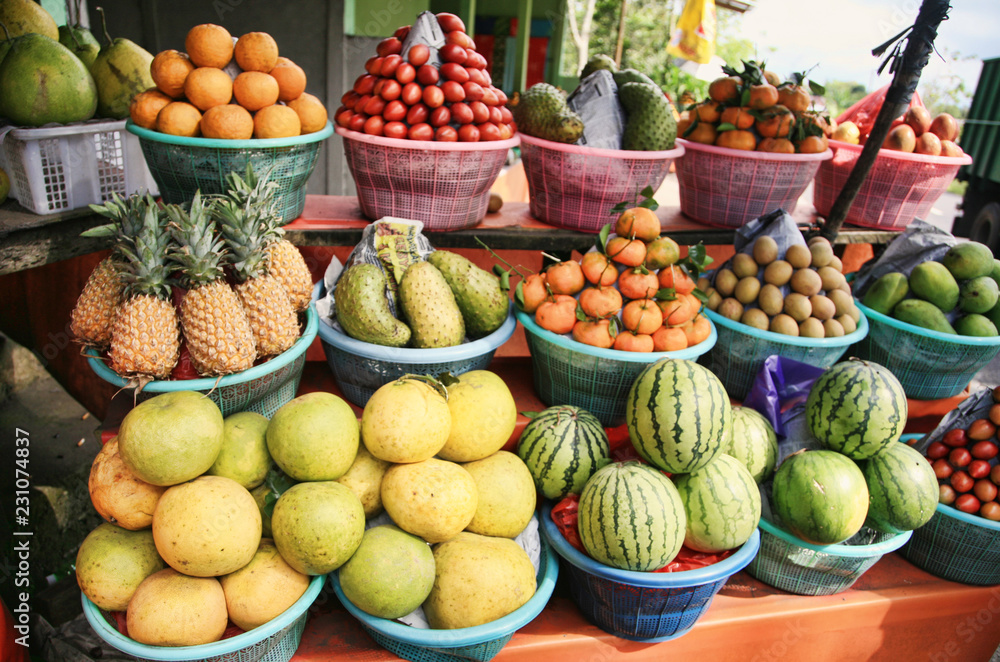 Exotic fruits - pineapples, tangerines, water melons, avocados - sold on the streets of Bali, Indonesia 