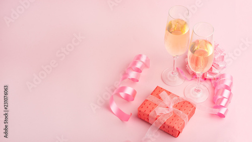 Champagne, gift, bow. Invitation, birthday, party on the occasion of girlhood, the concept of a baby shower, a holiday on a pink background. Banner for inscriptions, announcements for birthday
