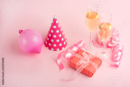Champagne, gift, bow. Invitation, birthday, party on the occasion of girlhood, the concept of a baby shower, a holiday on a pink background. Banner for inscriptions, announcements for birthday