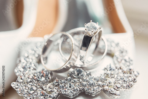 Classy silver wedding rings made of white gold lie on the crystal bracelet