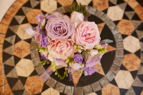 Look from above at violet wedding bouquet standing on the wooden table