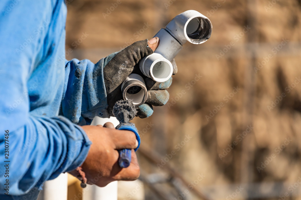 Plumber Applying Pipe Cleaner, Primer and Glue to PVC Pipe At
